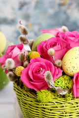 Woman shows how to make Easter table decoration with roses, moss and catkins