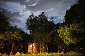 vintage country house at night with clouds and stars. Cold Autumn night, Wooden garden shed in a beautiful park