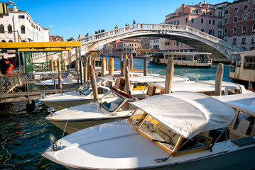 Motor boat taxi parked in front of arch bridge in Venice.