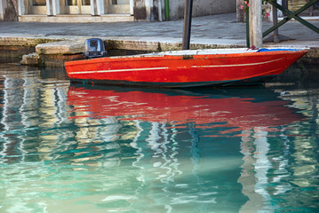 Fototapeta na wymiar Red motor boat docked Grand Canal in Venice, Italy.