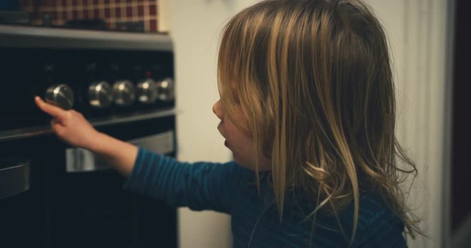 Little toddler turning on the oven
