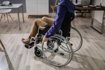 Businessman Sitting On Wheelchair In Office