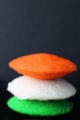 Tiranga Idli or Tricolor Idly cooked in  Indian National Flag colors - saffron or orange, white and green. Served with tiranga chutney. Concept for Indian Independence or Republic day greeting card. 