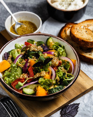 Salad with cucumbers, red and yellow tomatoes, red onions, basil and walnut sauce