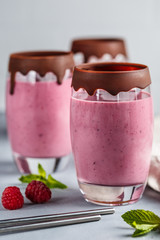 Raspberry banana smoothie in glasses covered with chocolate