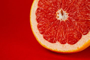 Grapefruit ripe and juicy and healthy, shot large on a red background