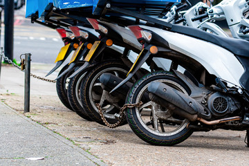 The rear wheels of the pizza delivery scooter chain are locked with an anti-theft chain