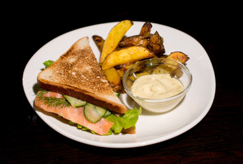 sandwich with salmon and fried potatoes