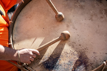 Musician hands with drum sticks playing a bass drum during an outdoor festival