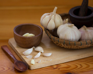 Raw garlic and garlic bulb in mortar and pestle