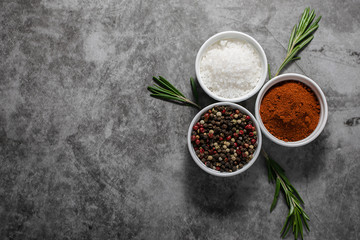 Spices, herbs and sea salt on dark concrete background with copy space for your design.