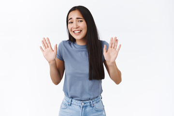 Girl trying jokingly refuse strange offer, step back and laughing awkward, raising hands up in...