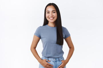 Business and education concept. Pleasant, cheerful asian woman, hold hands in jeans pockets and...