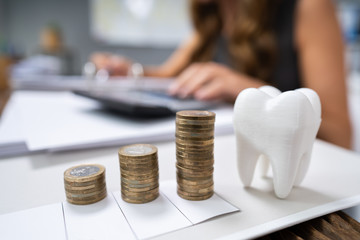White Tooth In Front Of Woman Calculating Bill
