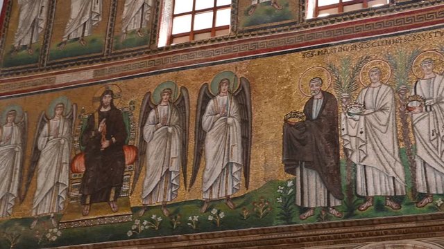Ravenna, Italy, December 2019. Basilica of Sant'Apollinare Nuovo. Footage with pan movement on the detail of the mosaics along the sides of the main nave. Jesus with angels beside receives the martyrs