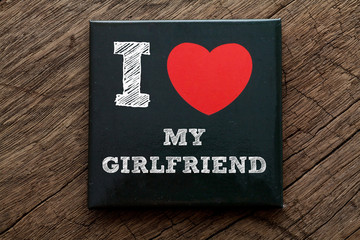 I Love My Girlfriend written on black note with wood background