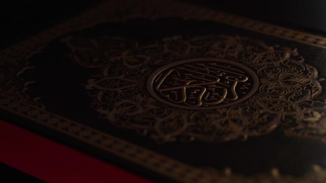 light on Quran Islam holy book of Muslims, the Quran, is placed on table , Holy Quran with arabic calligraphy meaning of Al Quran, islamic background