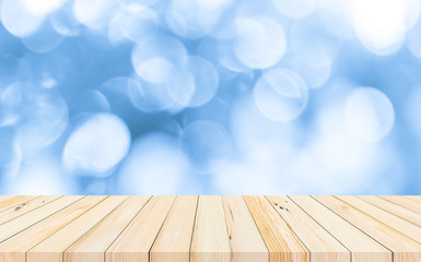 wood desk or wood floor with abstract blue bokeh background for products display