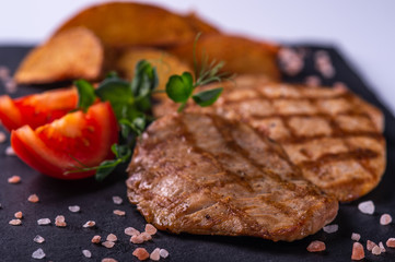  grilled meat and fried potatoes and fresh vegetables