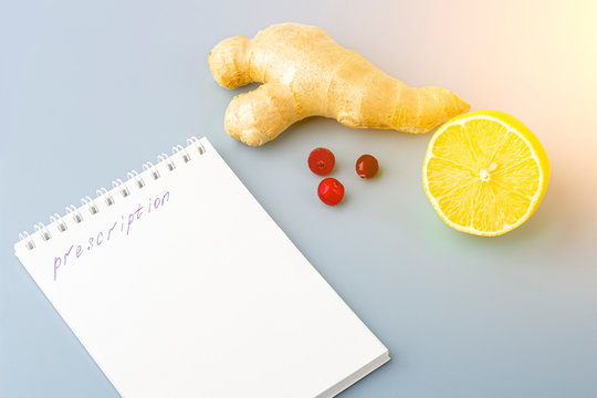 Natural medicine: cranberries, lemon, ginder and prescription on blue, copy space for text, close up. The concept of seasonal diseases and treatment of colds, flu, heat.