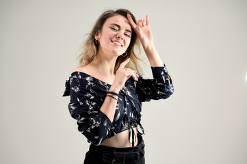 Fototapeta premium Concept woman in a dark shirt smiles and talks. Photo Portrait of a girl model with excellent makeup with good teeth in the studio on a white background.