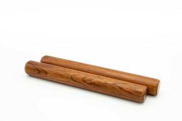 A pair of wooden claves lying on a white underground