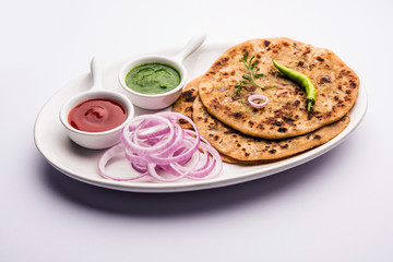 Onion Parotha / Pyaj parantha / kanda paratha served with tomato ketchup and green chutney. selective focus