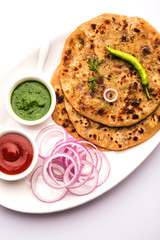Onion Parotha / Pyaj parantha / kanda paratha served with tomato ketchup and green chutney. selective focus