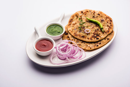Onion Parotha / Pyaj parantha / kanda paratha served with tomato ketchup and green chutney. selective focus