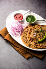 Onion Parotha / Pyaj parantha / kanda paratha served with tomato ketchup and green chutney. selective focus