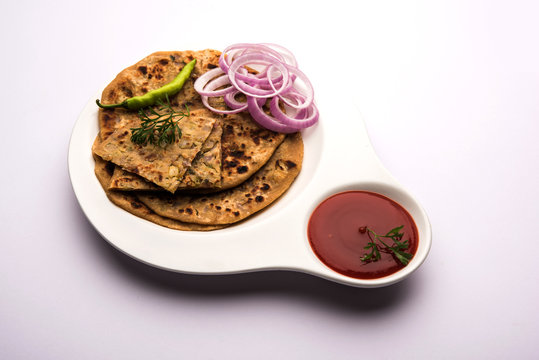 Onion Parotha / Pyaj parantha / kanda paratha served with tomato ketchup and green chutney. selective focus