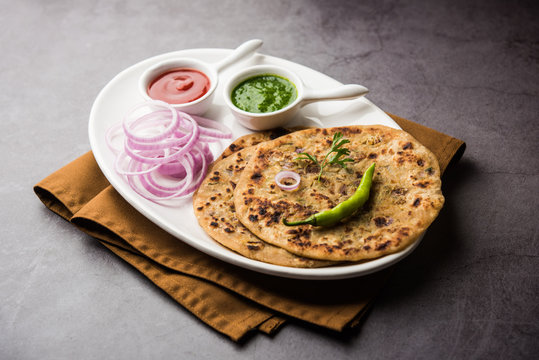 Onion Parotha / Pyaj parantha / kanda paratha served with tomato ketchup and green chutney. selective focus