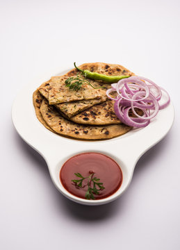 Onion Parotha / Pyaj parantha / kanda paratha served with tomato ketchup and green chutney. selective focus