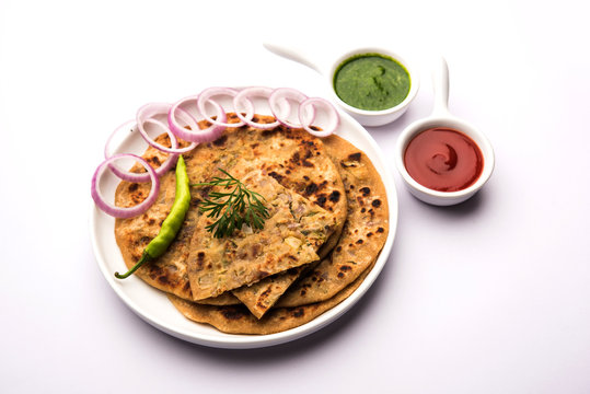 Onion Parotha / Pyaj parantha / kanda paratha served with tomato ketchup and green chutney. selective focus