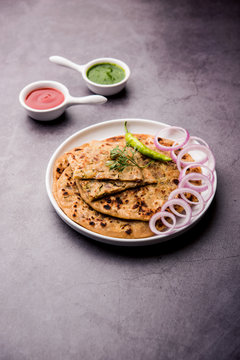Onion Parotha / Pyaj parantha / kanda paratha served with tomato ketchup and green chutney. selective focus