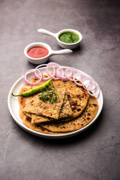 Onion Parotha / Pyaj parantha / kanda paratha served with tomato ketchup and green chutney. selective focus
