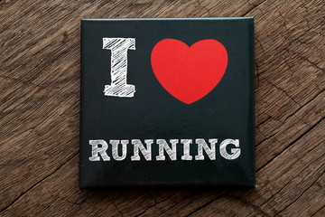I Love Running written on black note with wood background