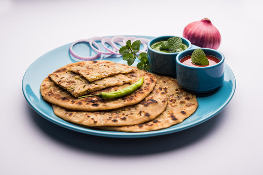 Onion Parotha / Pyaj parantha / kanda paratha served with tomato ketchup and green chutney. selective focus