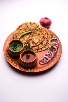 Onion Parotha / Pyaj parantha / kanda paratha served with tomato ketchup and green chutney. selective focus