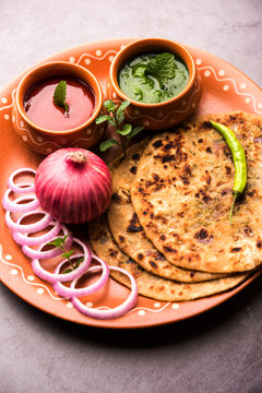 Onion Parotha / Pyaj parantha / kanda paratha served with tomato ketchup and green chutney. selective focus
