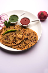 Onion Parotha / Pyaj parantha / kanda paratha served with tomato ketchup and green chutney. selective focus