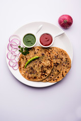 Onion Parotha / Pyaj parantha / kanda paratha served with tomato ketchup and green chutney. selective focus