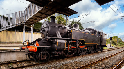 Old vintage steam train or locomotive arrived at station or platform, Greystones, Ireland