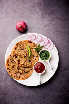 Onion Parotha / Pyaj parantha / kanda paratha served with tomato ketchup and green chutney. selective focus