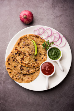 Onion Parotha / Pyaj parantha / kanda paratha served with tomato ketchup and green chutney. selective focus