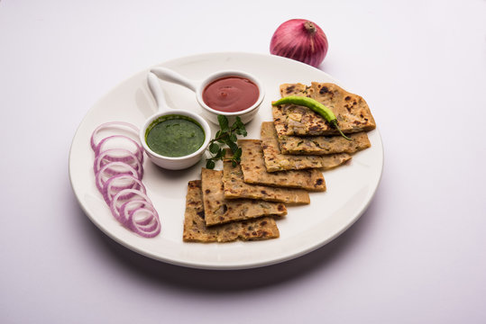 Onion Parotha / Pyaj parantha / kanda paratha served with tomato ketchup and green chutney. selective focus