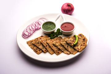 Onion Parotha / Pyaj parantha / kanda paratha served with tomato ketchup and green chutney. selective focus