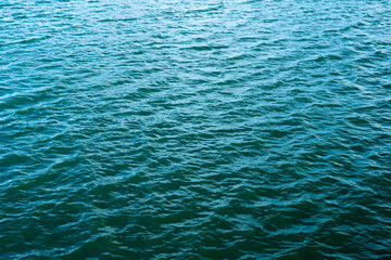 Ocean wave on tropical beach with golden sand and ripple of water splash from emerald blue-green sea water during summer vacation.