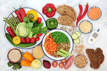 Low GI diet food for diabetics with blood sugar testing device with foods high in vitamins, minerals, antioxidants & smart carbs. Below 55 on the GI index with corresponding values. Top view.