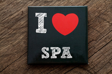 I Love SPA written on black note with wood background